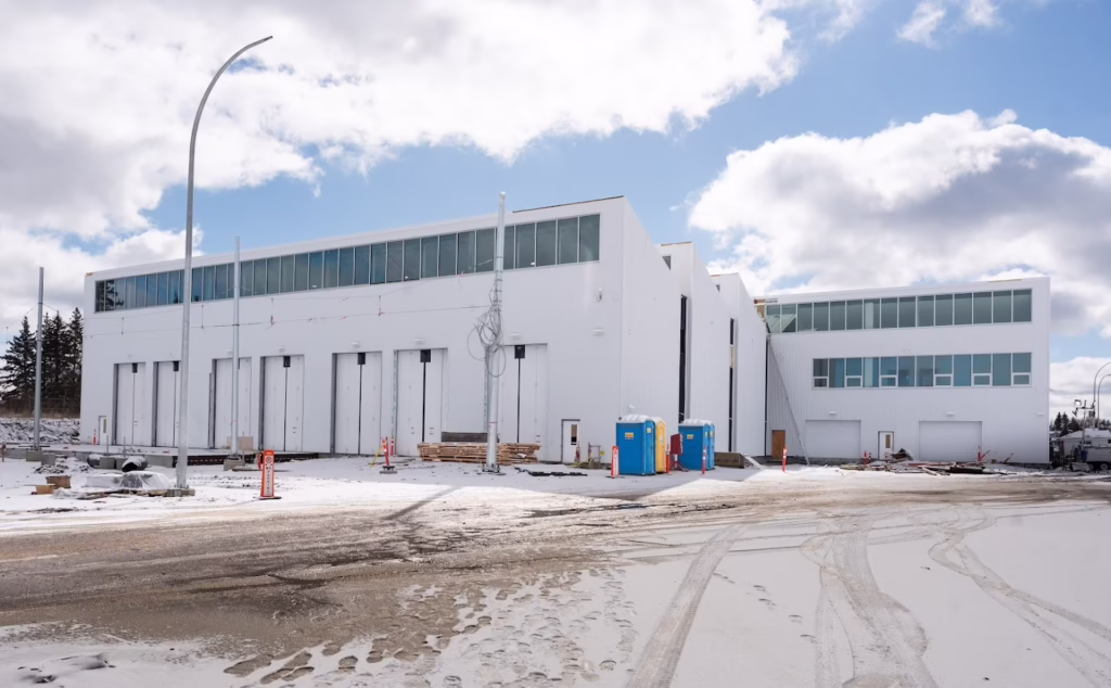 Winter view of outdoor bi-fold and sectional commercial doors at the Lewis Farms LRT Facility in Edmonton, supporting transit infrastructure operations.